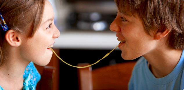 Petite fille et petit garçon en train de manger des spaghettis